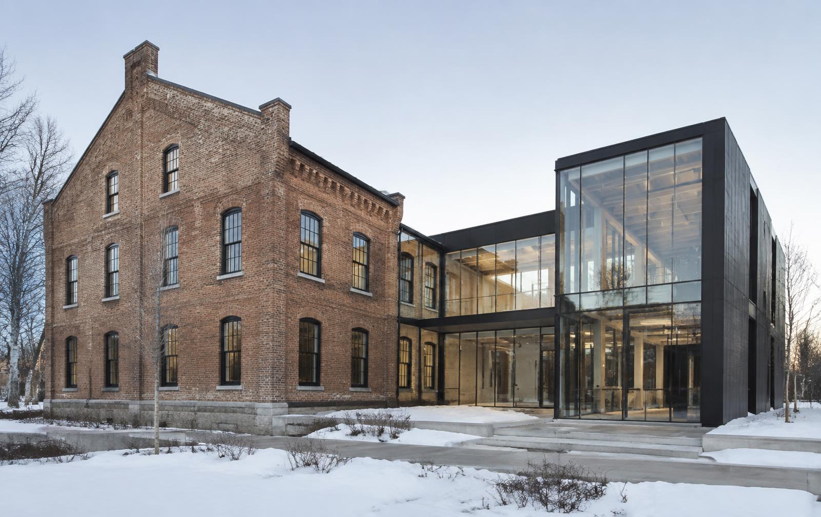 Historic brick building with a modern glass addition in winter